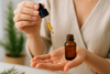 Unscrew the lid and take about five drops of rosemary essential oil in hand create picture of tis that women put seram in her hand
